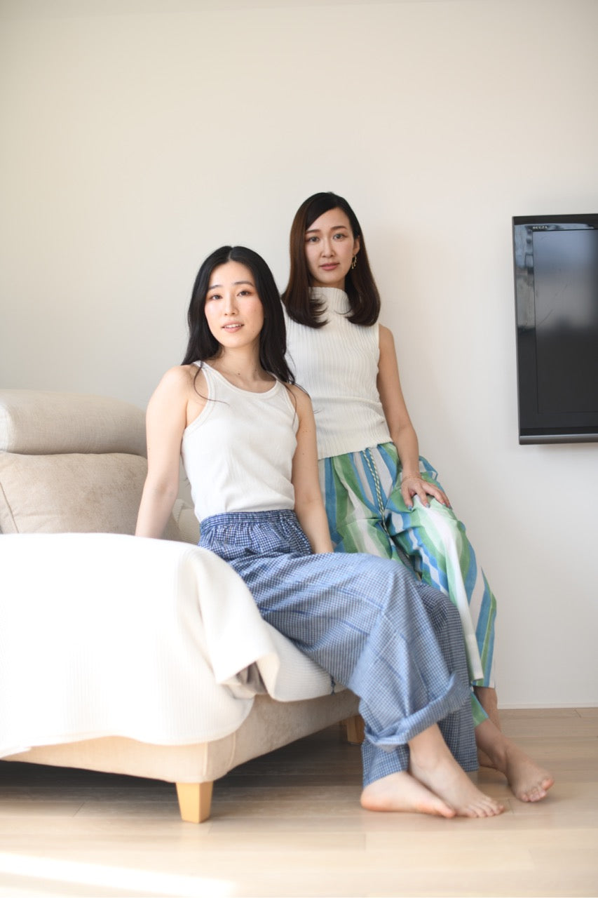 Two women sitting on a couch in a living room.