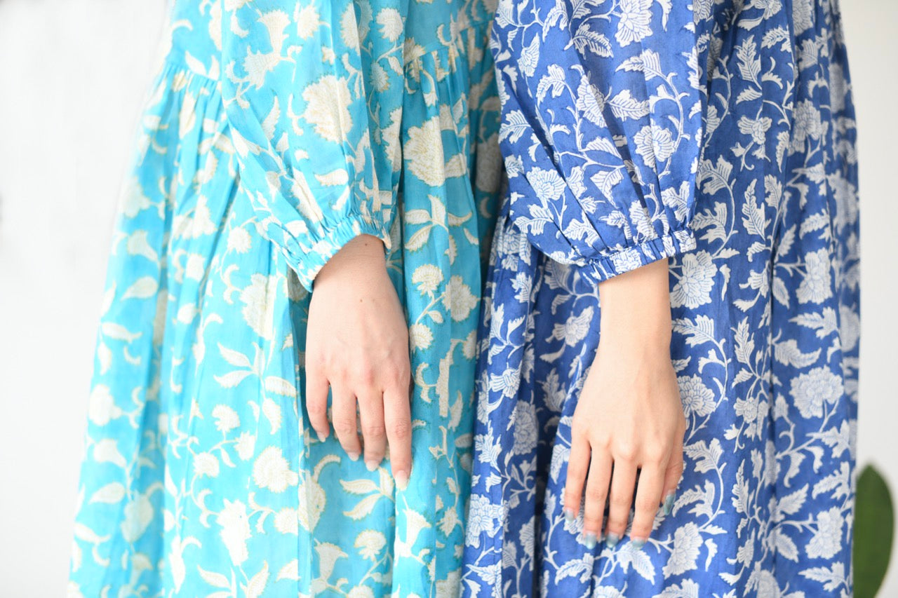 Two floral-patterned dresses in blue and light blue on a white background