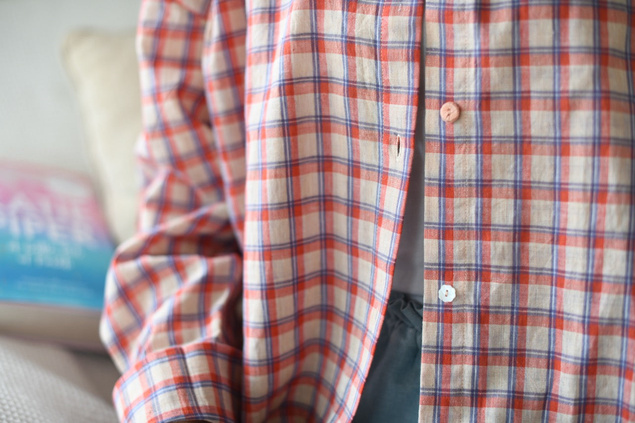 Red and white checkered shirt on a couch with a blurred background
