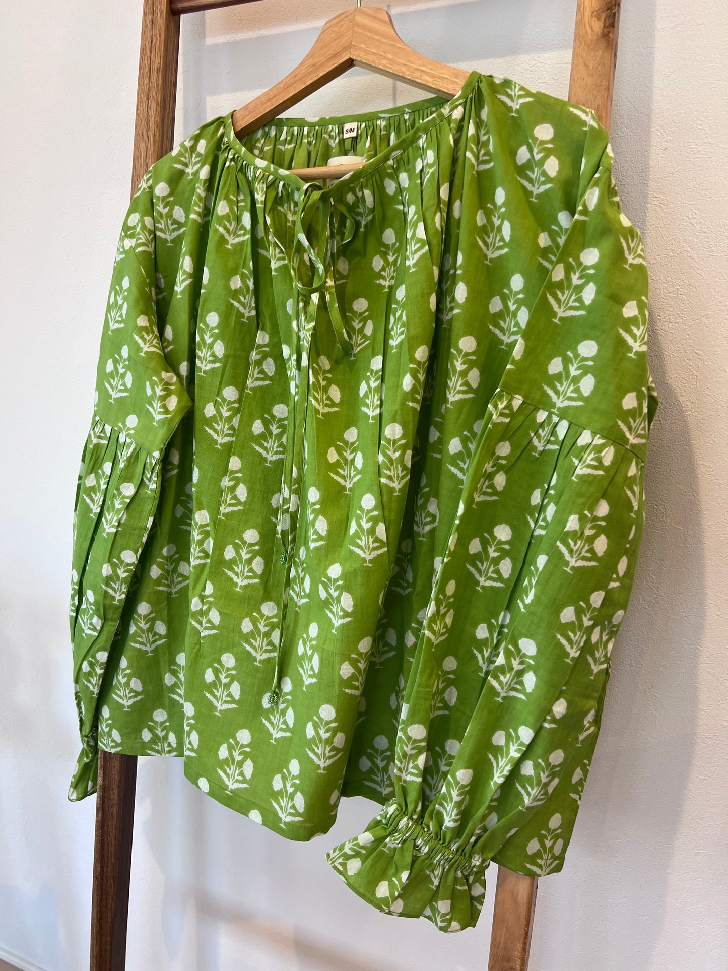 Flouncy top with volume sleeves and ruffles at the cuff in a neon green shade with a floral motif print