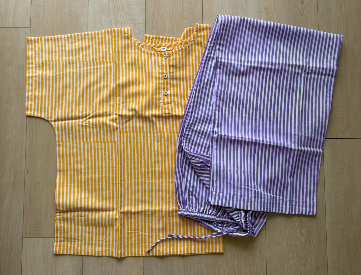 Yellow and purple striped shirt and pants on a wooden floor