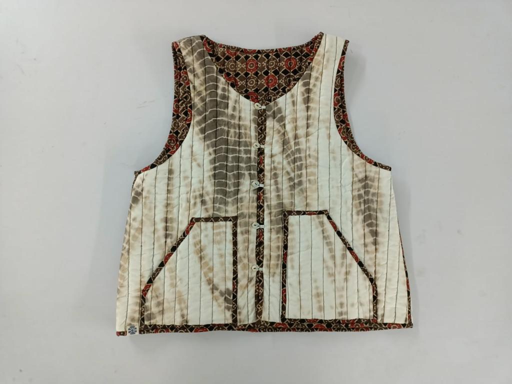 Brown reversible ajrakh and natural dye shibori sleeveless quilted cotton jacket. 
