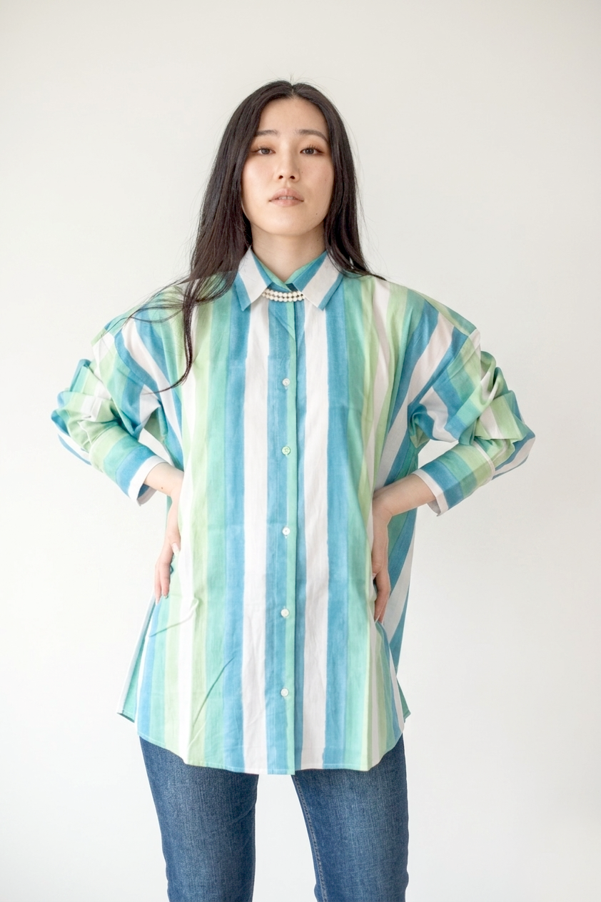 Woman wearing a colorful striped shirt against a white background