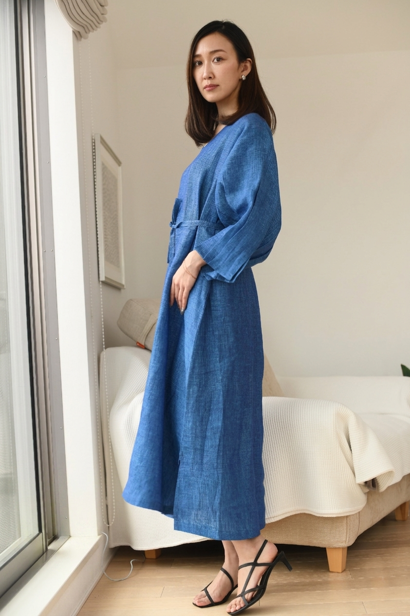 Woman wearing a blue dress standing in a room.