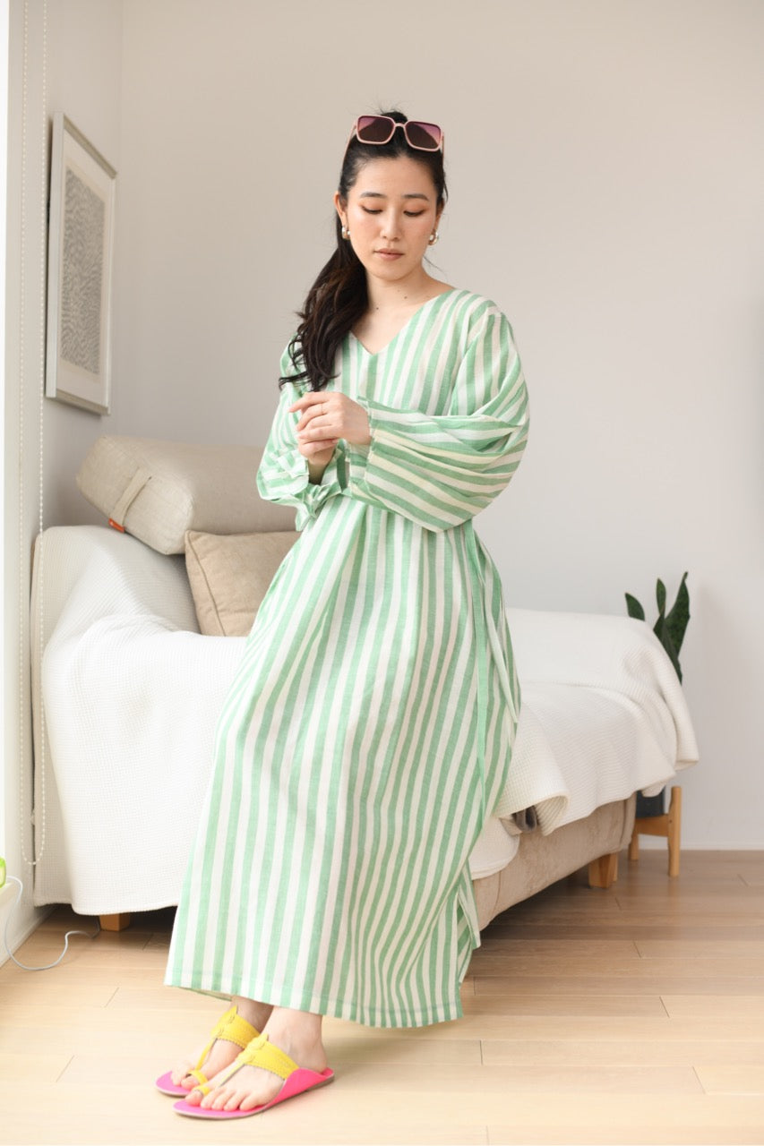 Woman in a green and white striped dress standing in a room