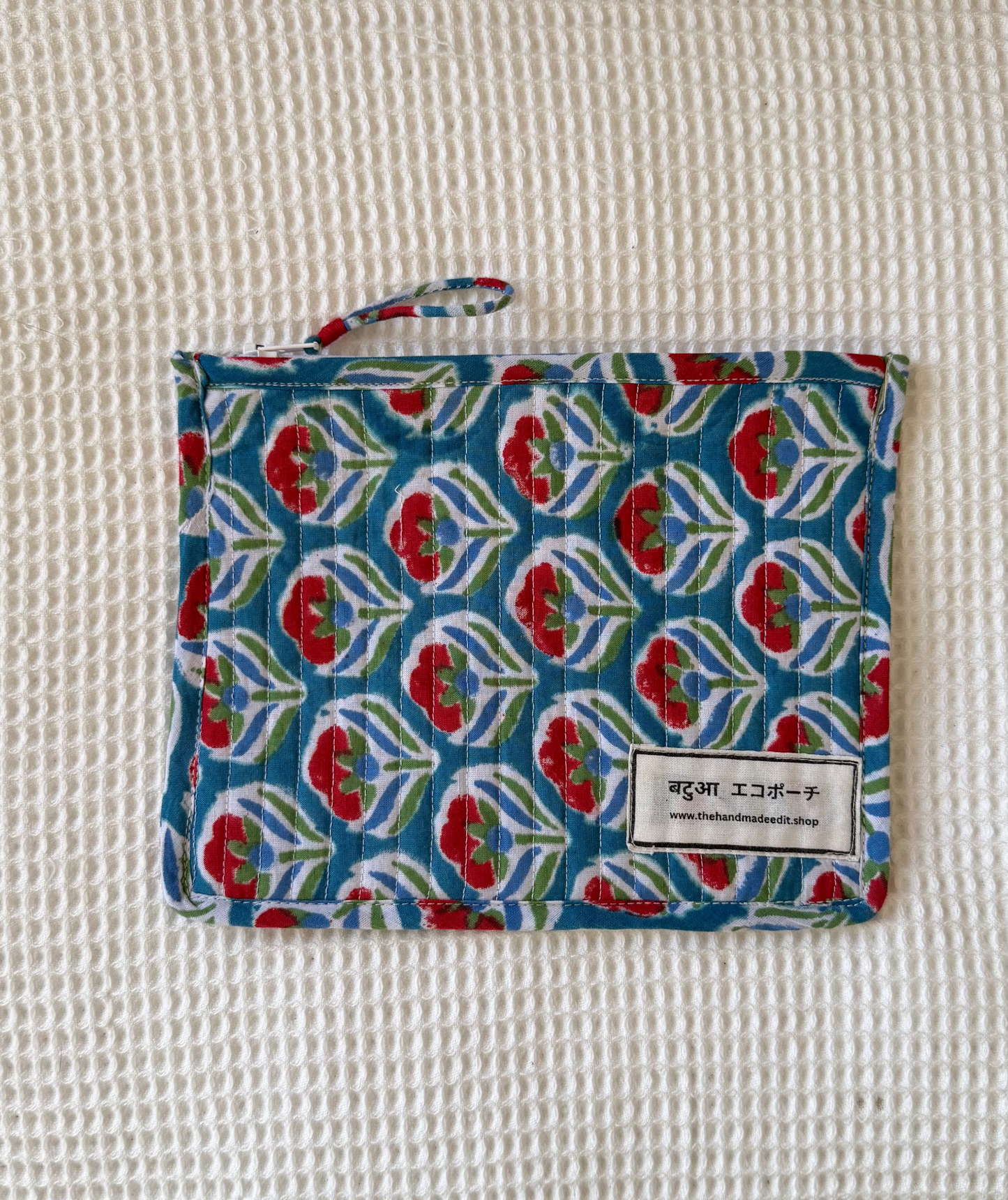 Fabric pouch with floral pattern on a textured surface