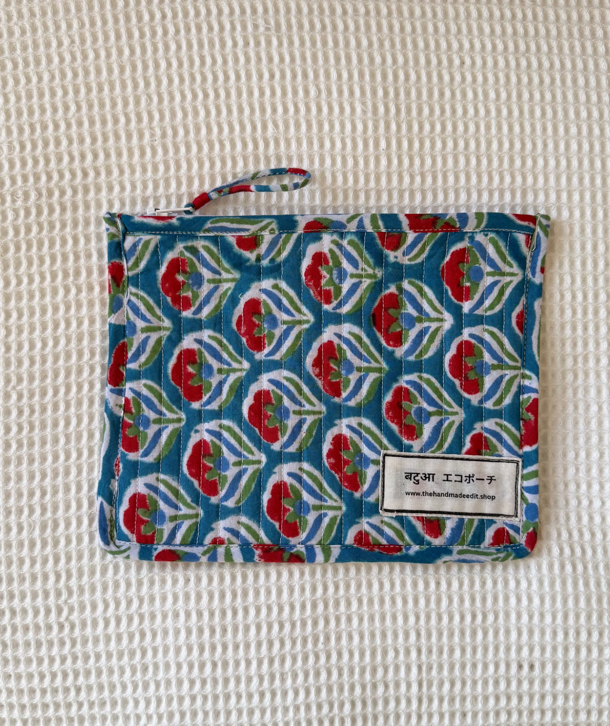 Fabric pouch with floral pattern on a textured surface
