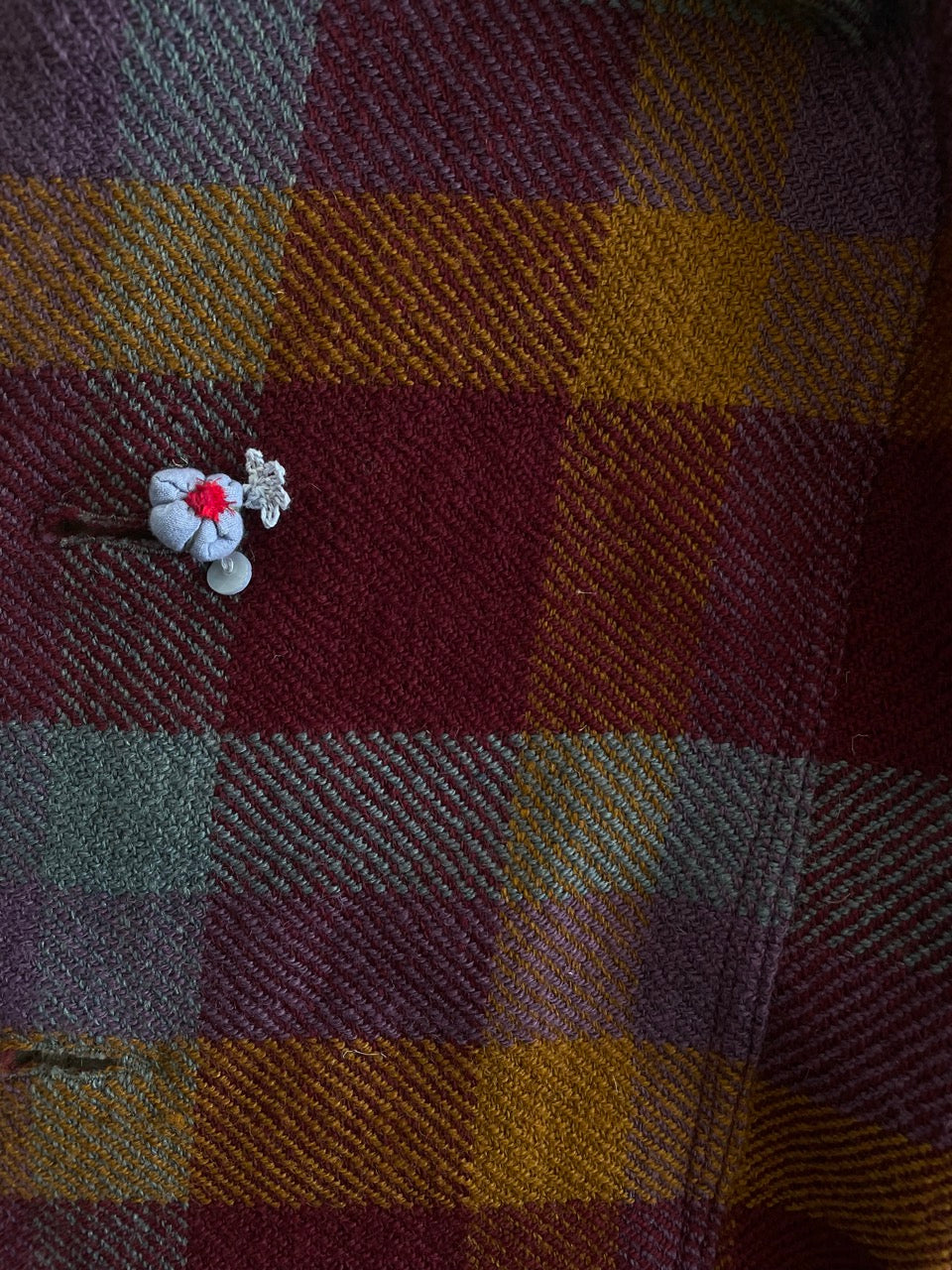 handmade flower on Handwoven soft merino wool long jacket in berry coloured checks.  肌寒い時期にぴったりのチェックのロングジャケットは、手織りのメリノウールで作られています
