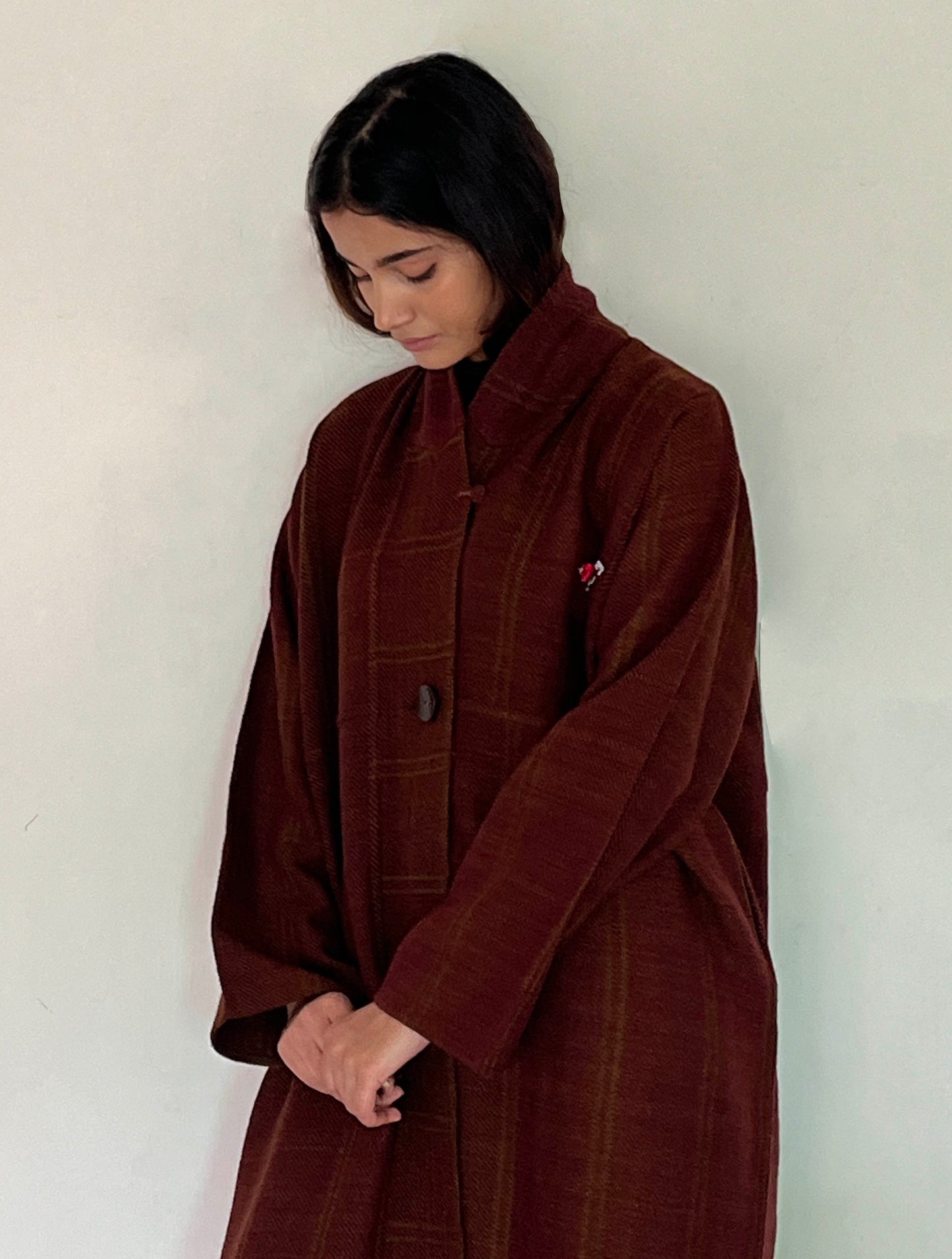 earth red hand woven merino wool long jacket. このロングジャケットは、手織りのメリノウールで作られています。
