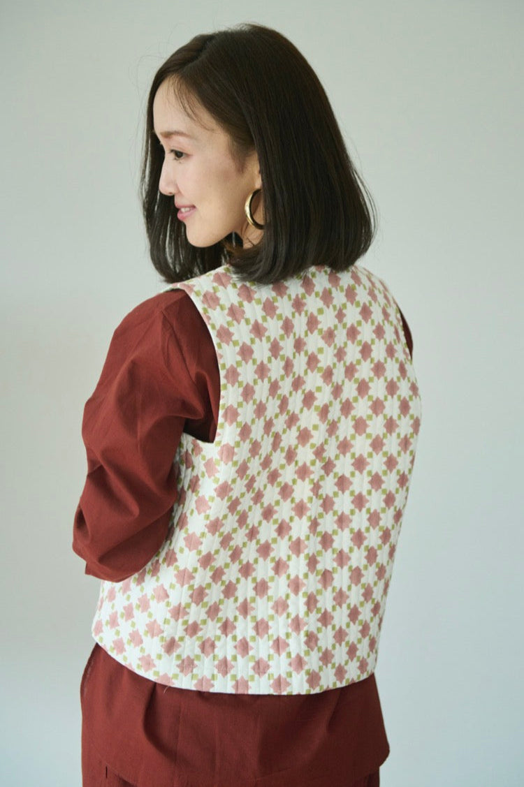 Quilted cropped vest in sage green and apricot made with hand block printed cotton with a geometric cut armhole and contrast print lining