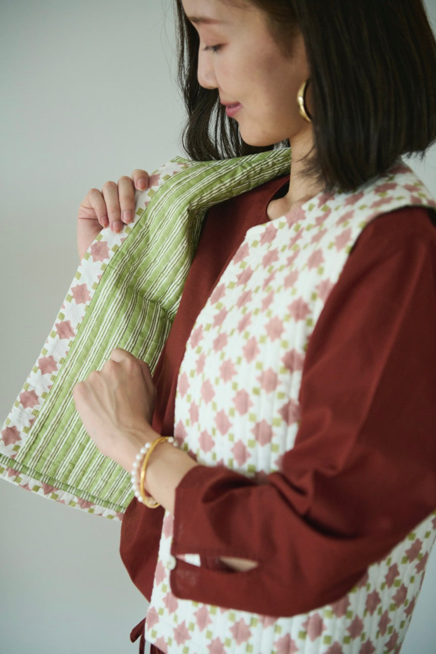 Quilted cropped vest in sage green and apricot made with hand block printed cotton with a geometric cut armhole and contrast print lining