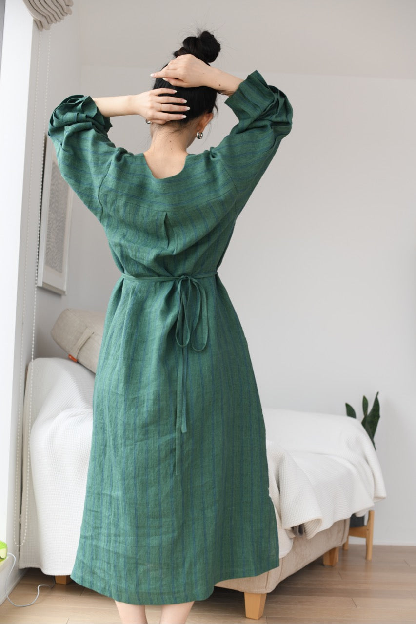 Person wearing a green linen dress in a room