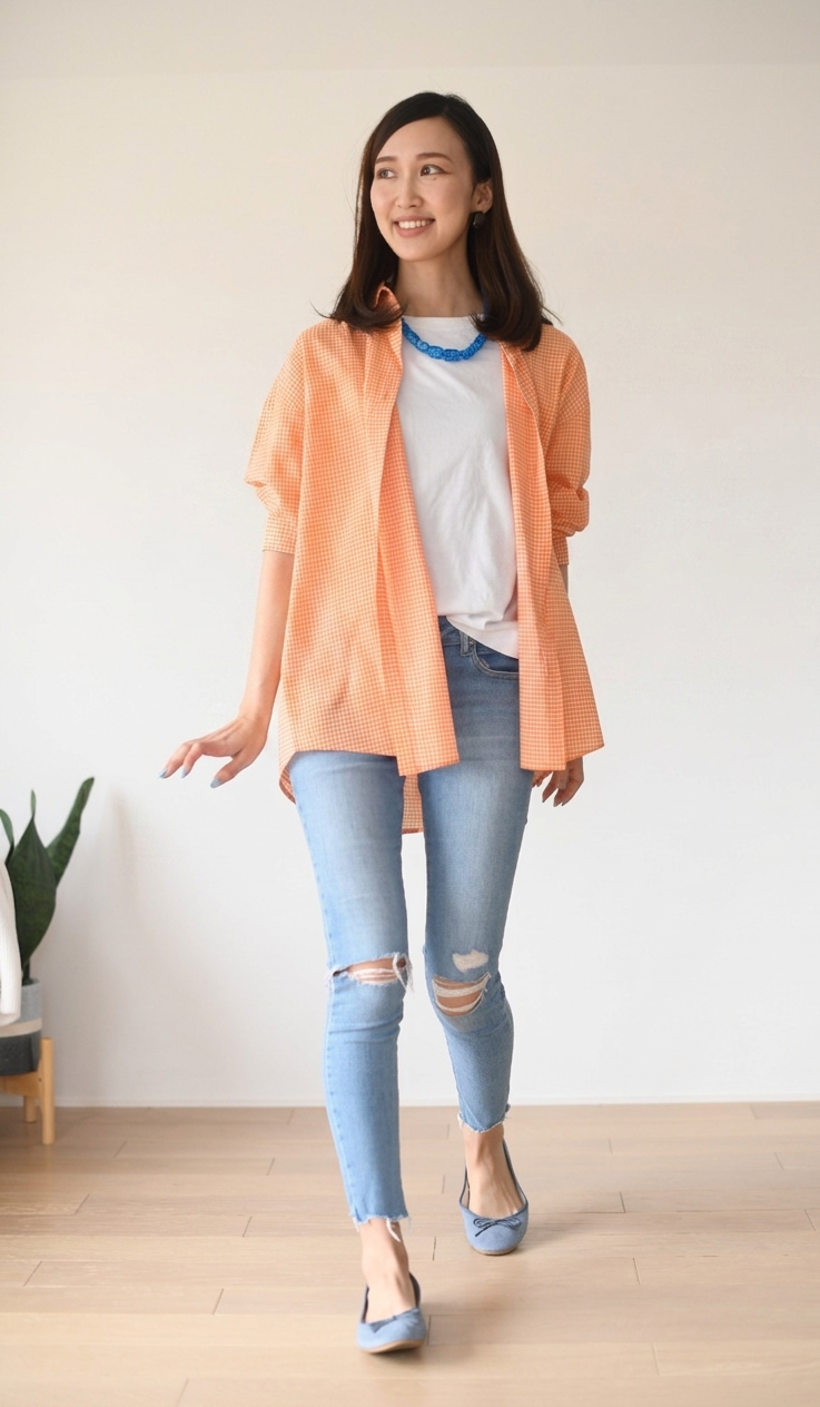 Woman wearing a peach shirt, white T-shirt, and light blue jeans indoors.